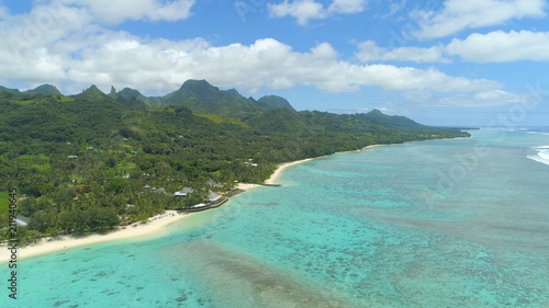 AERIAL  Spectacular view of beachfront hotel and mountains on exotic island.
