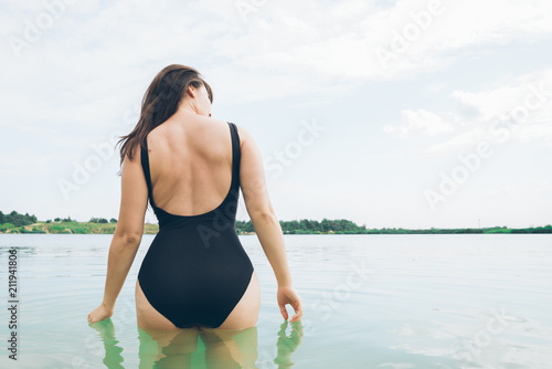 Fototapeta Naklejka Na Ścianę i Meble -  sexy woman walking into water in swimming suit