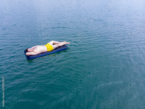 man on mattress in blue water. summer time concept © phpetrunina14