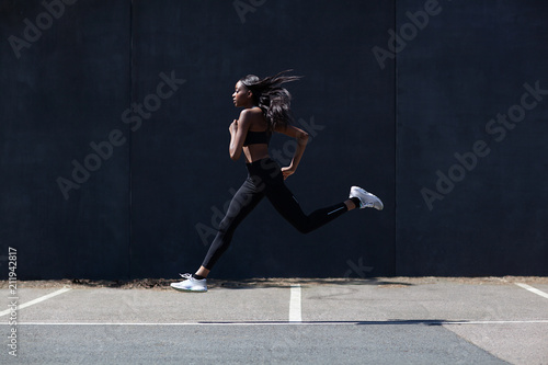 Young woman running on sports court