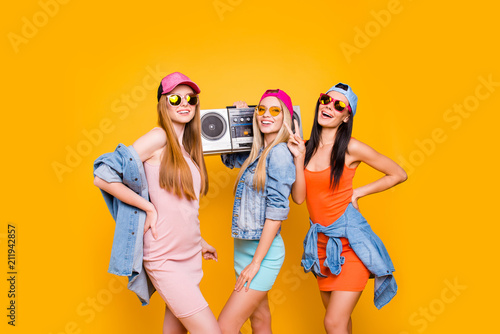 Stereo fan song sound audio cassette tape hip-hop old school lover portable culture concept. Portrait of funky trio gesturing peace symbol having rest relax isolated on vivid yellow background