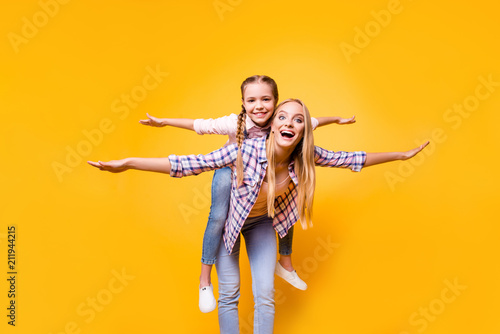 Parenthood siblings game checkered shirt stylish modern outfit concept. Excited cheerful cute funky carefree pretty mum carrying on back kid making airplane winds isolated on bright background