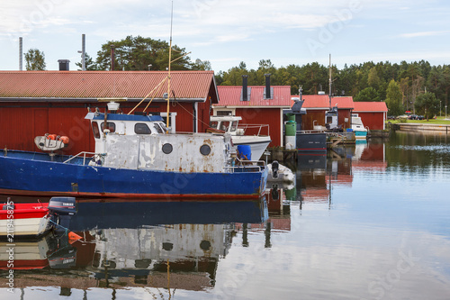 Fishing boats in the harbor at their boathouses photo