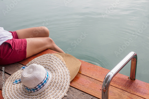woman in big hat relaxing on the swimming pool