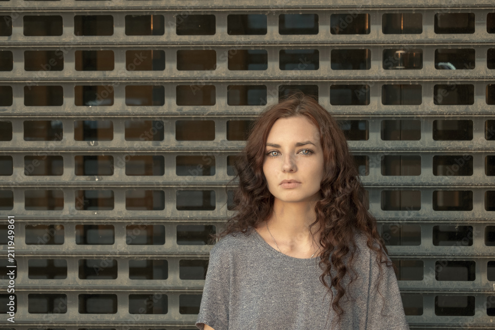 Depressed Girl In front Of metal Mesh. Teenager Prisoner