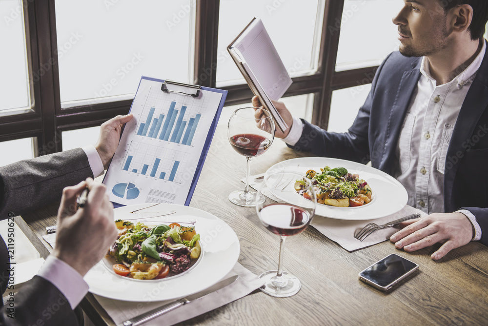 Two Businessmen Have Lunch with Wine in Restaurant Two Businessmen Have Lunch with Wine in Restaurant