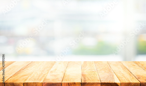 Wood table top on blur white glass wall background form office building