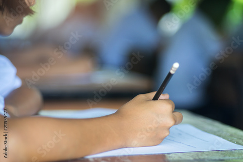 Students taking exam with stress in school classroom.