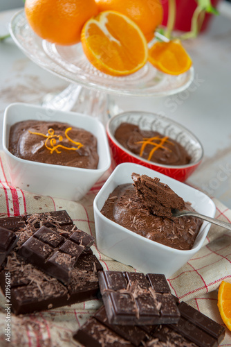 close up of dark chocolate mousse with tablets and oranges