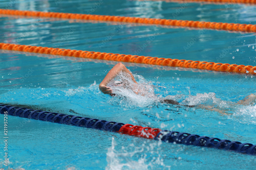 Swimmer swims free style, front crawl or forward crawl stroke in a swimming pool for competition or race