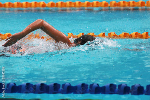 Swimmer swims free style, front crawl or forward crawl stroke in a swimming pool for competition or race