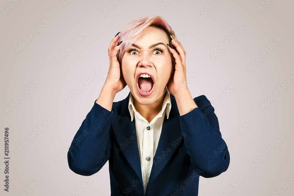 Young girl office worker screams for fear, isolated on a pink background Young girl office worker screams for fear, isolated on a pink background