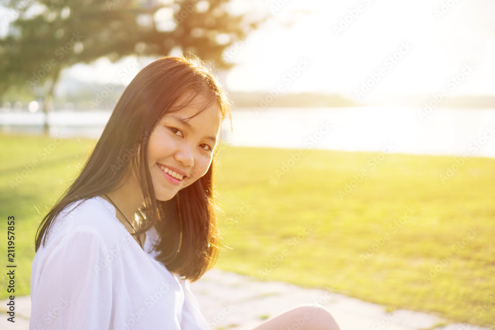 Young Asian girl in a public park near the beach during sunset. Portrait shot from side view. Young Asian girl in a public park near the beach during sunset. Portrait shot from side view.
