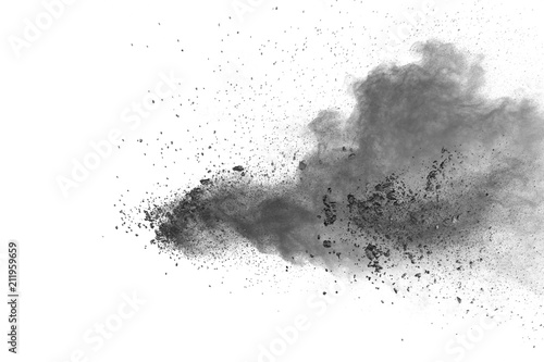 Black powder explosion against white background.Closeup of black dust particles explode isolated on white background.