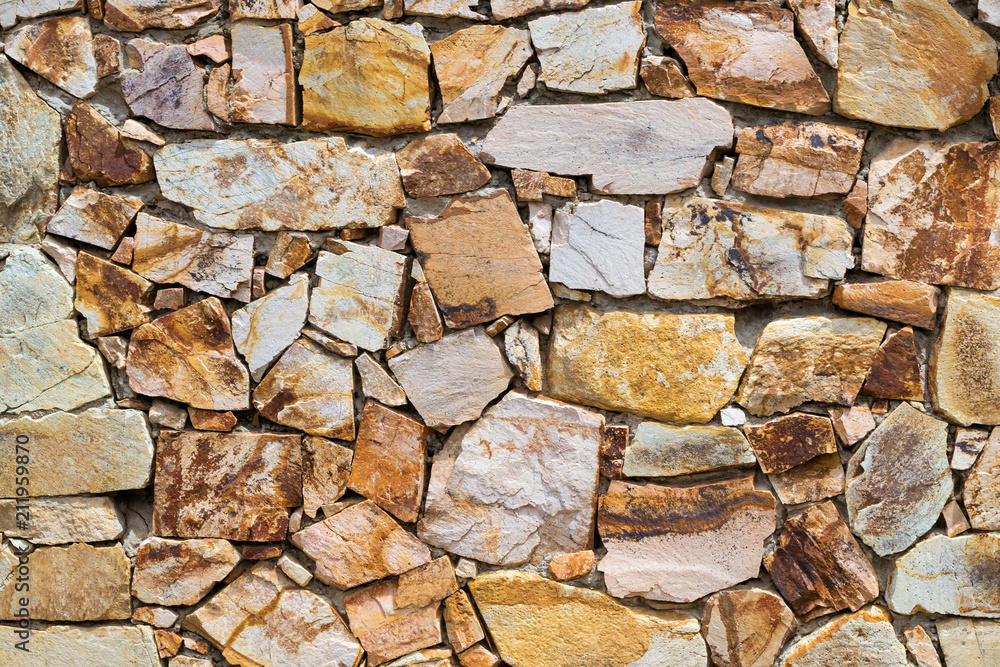 Decorative stone wall, pieces of rock bonded with cement. Cobble texture with cracks. Mountain of castle San Juan. Spanish beach resort Blanes in summertime, Costa Brava, Catalonia, Spain Decorative stone wall, pieces of rock bonded with cement. Cobble texture with cracks. Mountain of castle San Juan. Spanish beach resort Blanes in summertime, Costa Brava, Catalonia, Spain