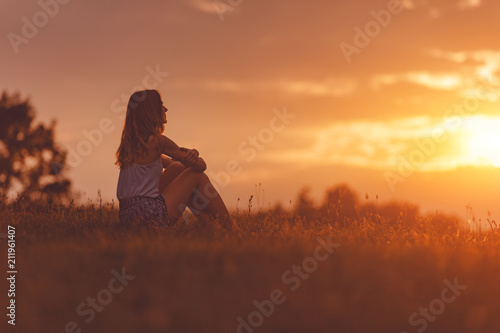 Slika na platnu Girl enjoying in the meadow at golden sunset time.