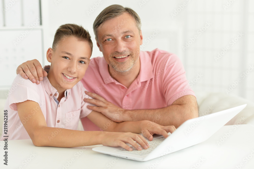 son and father using laptop son and father using laptop