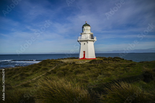 Travel New Zealand. Scenic view of white lighthouse on coast  ocean  outdoor background. Popular tourist attraction  Waipapa Point Lighthouse located at Southland  South Island. Travel concept.