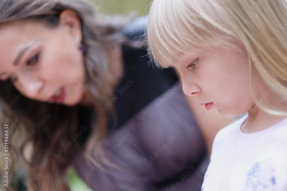 Profile of a little blond beautiful girl on the background of a woman Profile of a little blond beautiful girl on the background of a woman