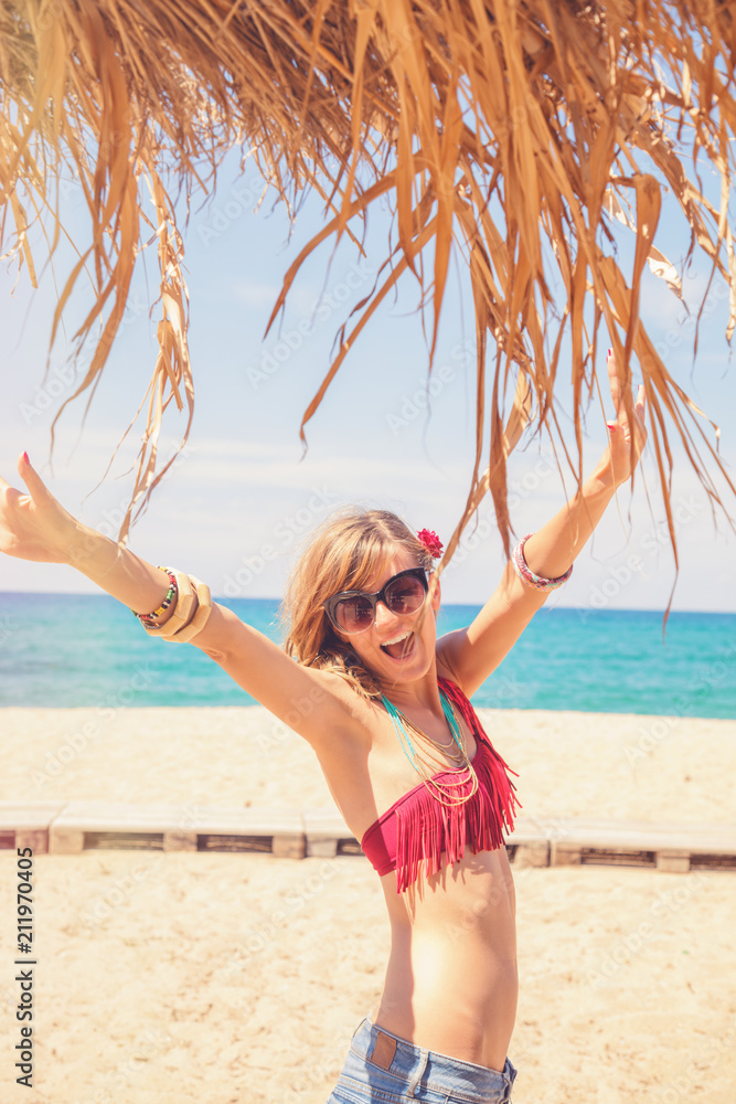 Naklejka premium Beautiful woman having fun on the tropical sandy beach. Summer concept.