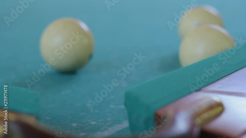 The ball from the billiard falls into the pocket photo
