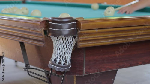 The player pushes the ball from the billiard to the pocket photo