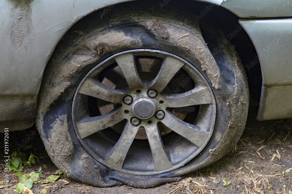 old and dirty car wheel deflated