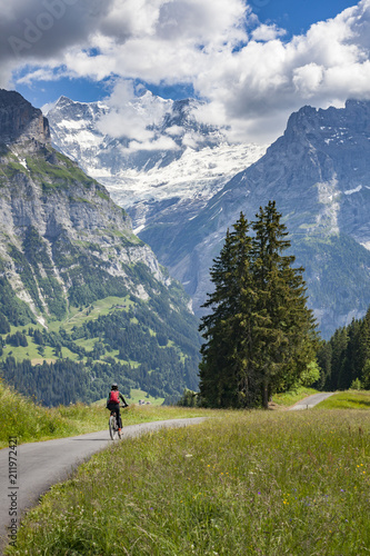 nice and ever young senior woman riding her e-mountainbike below the Eiger Northface near Grindelwald and Wengen, Jungfrauregion, Switzerland