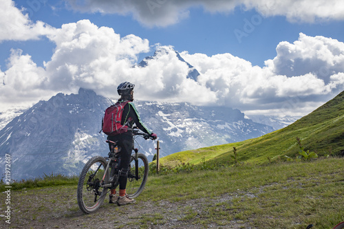 nice and ever young senior woman riding her e-mountainbike below the Eiger Northface near Grindelwald and Wengen, Jungfrauregion, Switzerland