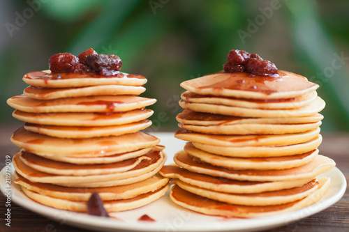 delicious pancakes on wooden table with strawberry jam