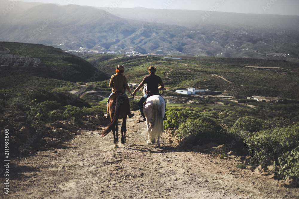 couple in love riding two beautiful horses stay together in a travel adventure for alternative lifestyle and vacation. togetherness couple traveling concept to discover the world and the future