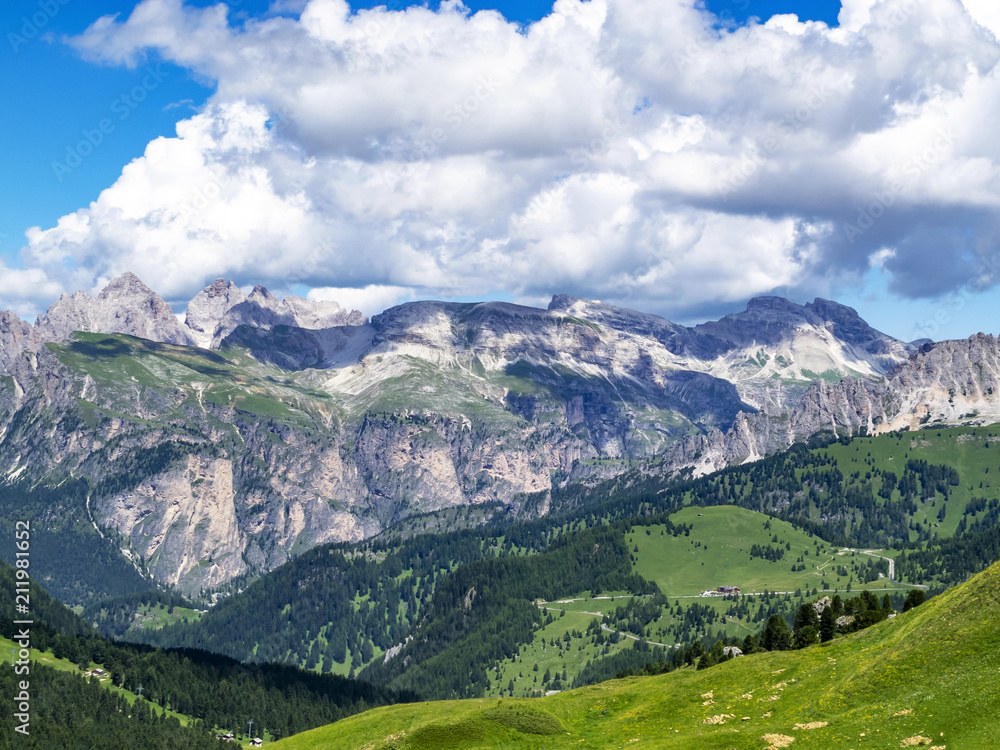 Picturesque July layered Alpine view from the Sella Pass in the Dolomites with big cumulus clouds, in South Tyrol, Italy