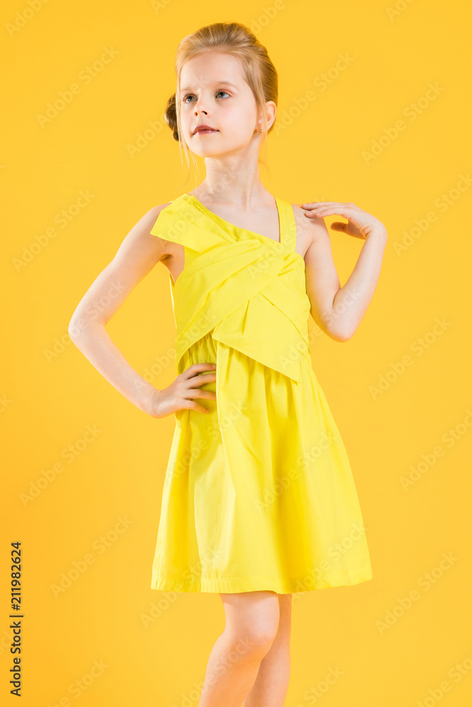 The blonde girl put one hand on her hip and the other holds her shoulder.