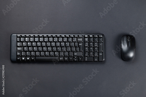 Wireless mouse with black keyboard on black surface