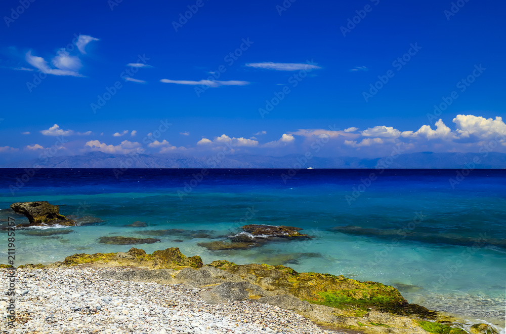 Picturesque summer beach, pebbles in the surf line on a beautiful turquoise sea, Rhodes, Greece