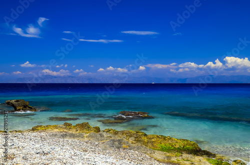 Picturesque summer beach  pebbles in the surf line on a beautiful turquoise sea  Rhodes  Greece