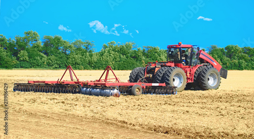 red tractor for harvesting in the midst of the summer season  produces disk field