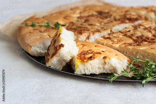 Traditional Italian focaccia with thyme on a light background. Homemade flat bread focaccia