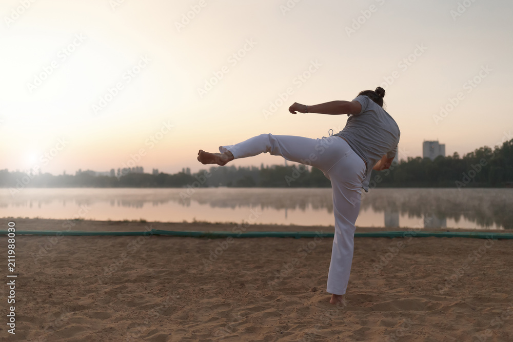 Obraz premium Capoeira performer near the lake in the parc