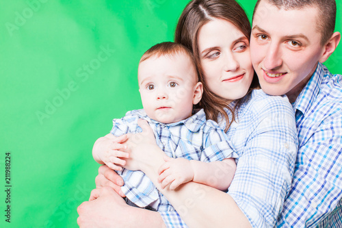 Young family portrait isolated on a green background