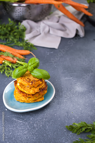 pancakes from carrot and basil, healthy food from vegetables. Gray background, bright vegetables. Copy space,