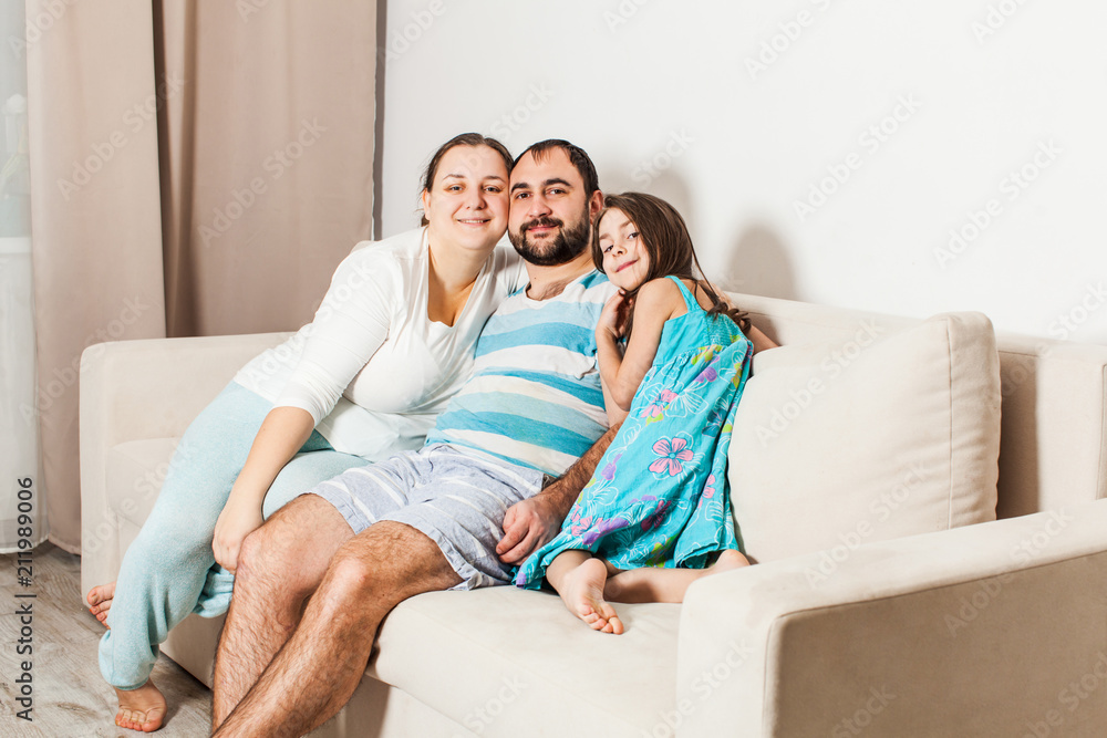 Beautiful family sitting on a couch in the living room.