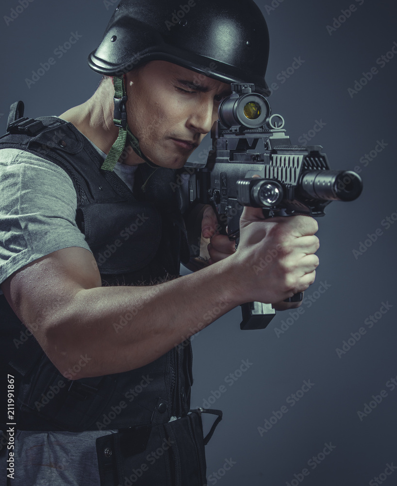 recreation player wearing protective helmet aiming pistol ,black armor and machine gun recreation player wearing protective helmet aiming pistol ,black armor and machine gun