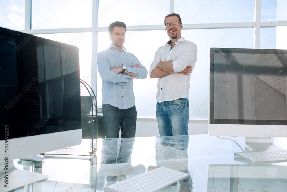 business background.two employees standing in a modern office. business background.two employees standing in a modern office.