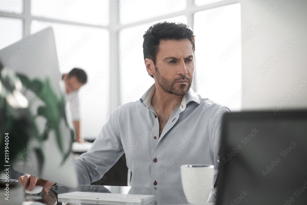 business man talking to a colleague sitting at his Desk business man talking to a colleague sitting at his Desk
