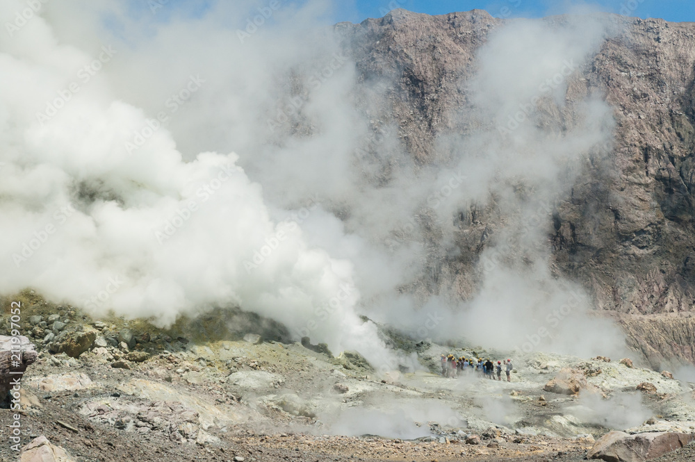 A group of tourists observing the thermal activity in the crater of the active volcano of White Island, Whakaari, off the Bay of Plenty coast, New Zealand.