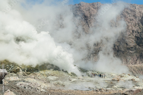 A group of tourists observing the thermal activity in the crater of the active volcano of White Island, Whakaari, off the Bay of Plenty coast, New Zealand.