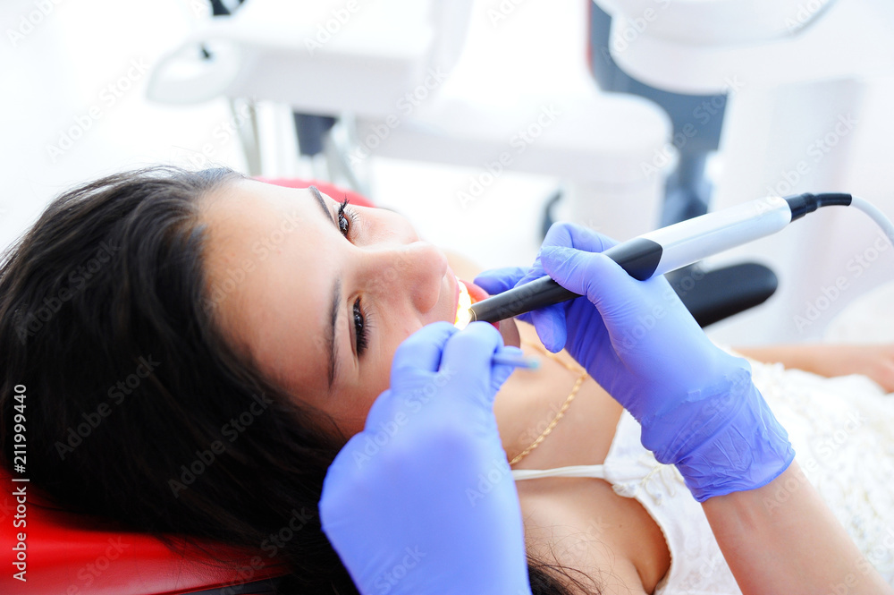 Young beautiful girl in dental office. Children's dentist examines teeth to a child. Young beautiful girl in dental office. Children's dentist examines teeth to a child.