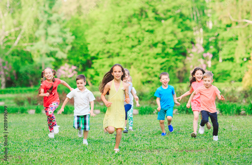 Many different kids, boys and girls running in the park on sunny summer day in casual clothes Many different kids, boys and girls running in the park on sunny summer day in casual clothes