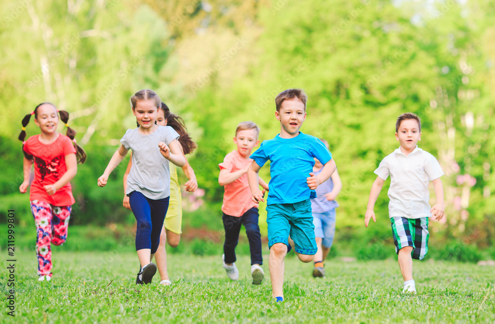Many different kids, boys and girls running in the park on sunny summer day in casual clothes Many different kids, boys and girls running in the park on sunny summer day in casual clothes